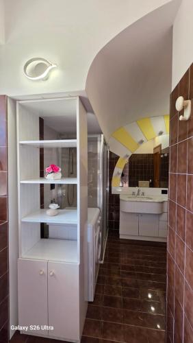 a kitchen with white cabinets and a sink and a bathroom at Casa Luisa in Recco