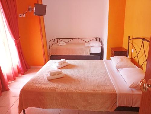 a bedroom with two beds with towels on them at Hotel Sarandos in Ammouliani