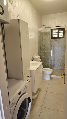 a bathroom with a toilet sink and a washing machine at Apartman Ljubo in Podgora
