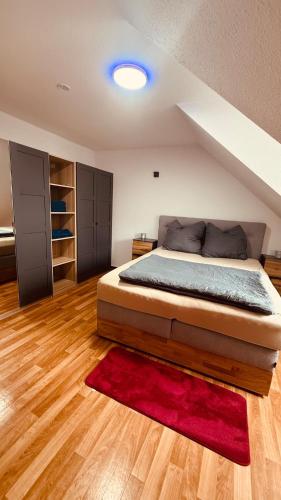 a bedroom with a bed and a red rug at Dachwohnung mit Südbalkon Sauna und Strandkorb in Mühlhausen