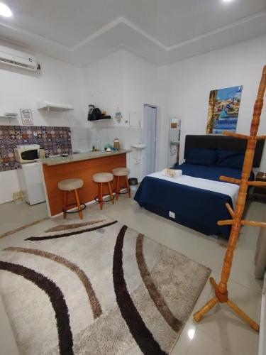 a bedroom with a bed and a kitchen with a counter at Durmaaquislz in São Luís