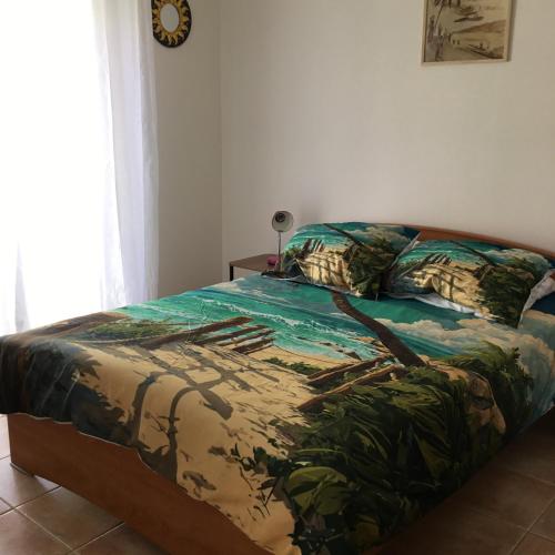 a bedroom with a bed with a green comforter at Marseillan in Marseillan
