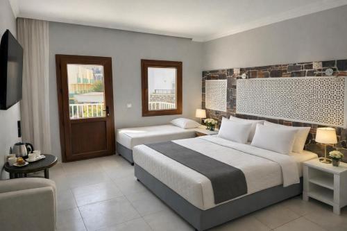 a hotel room with two beds and a couch and a television at Salinas Hotel in Gümbet