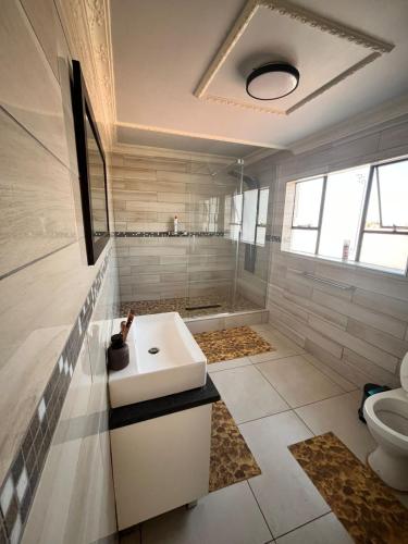 a bathroom with a sink and a toilet at Kingdoms Place Guesthouse in Ga-Luka