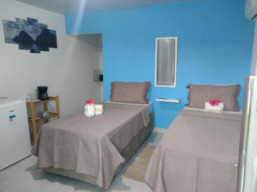 a room with two beds and a blue wall at Casa Noronha tropical 2 in Fernando de Noronha