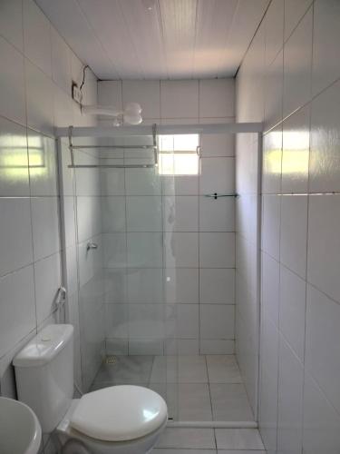 a white bathroom with a toilet and a shower at Casa Noronha tropical 2 in Fernando de Noronha