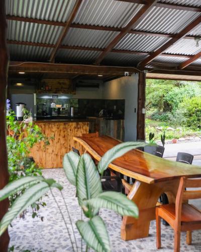 a patio with a wooden table and a kitchen at Kibutz Eco Guesthouse in Fortuna