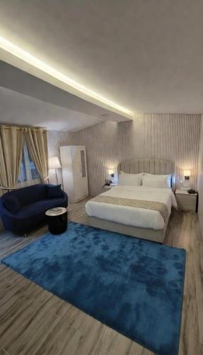a bedroom with a large bed and a blue rug at شاليه ياسمين حتا الخاص - Jasmin Hatta Private Chalet in Hatta
