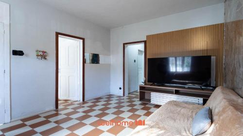 a living room with a couch and a flat screen tv at Casa Central em Petropolis 400m do Museu Imperial in Petrópolis