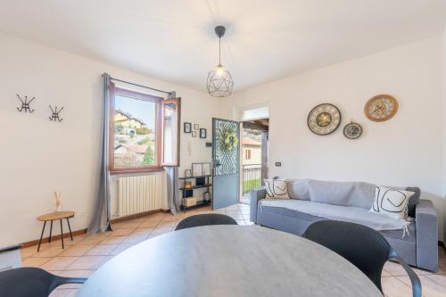 a living room with a table and a couch at L’Acero Rosso - Giardino privato e Box auto in Menaggio