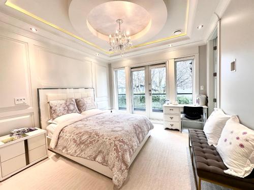 a bedroom with a large bed and a chandelier at Vancouver Shangrila House in Richmond