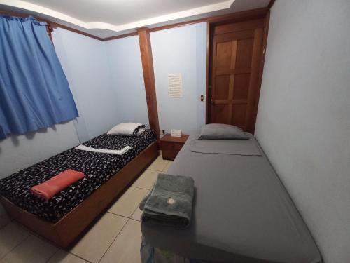 a small room with two beds and a door at Casa MONTOCO 114 in Managua