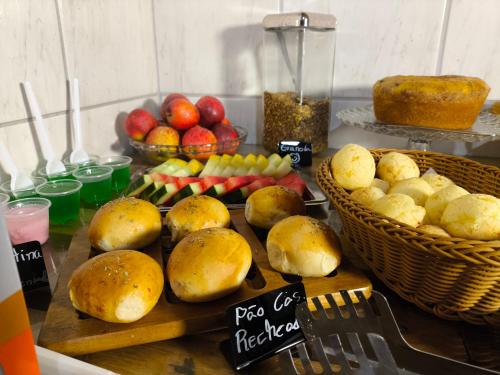 a table topped with baskets of fruit and bread at Hotel Villa Real in Diamantina