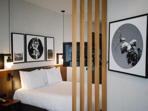 a bedroom with a bed and some pictures on the wall at Holiday Inn Telavi by IHG in Telavi