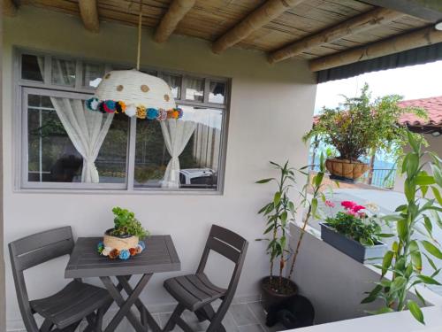 a patio with a table and chairs and plants at Hospedaje Finca Eje Cafetero, Casa Ne u in Marsella