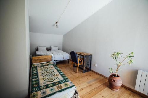 a bedroom with a bed and a potted plant at Green Sheep Boutique Hotel in Kazbegi
