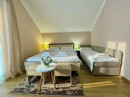 a bedroom with two beds and a table in it at Котедж в ГОРАХ in Solochyn