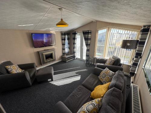 a large living room with couches and a tv at Golden Palm Resort - The Meridian - Coastal Caravan Breaks in Chapel Saint Leonards