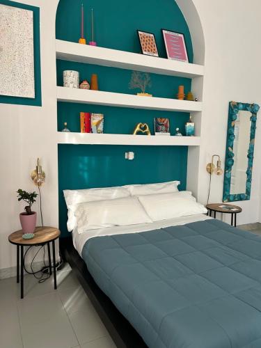 a blue bedroom with a bed and shelves at Caligo B&B Secret Garden Villa Room vicino alle Cinque Terre in La Spezia