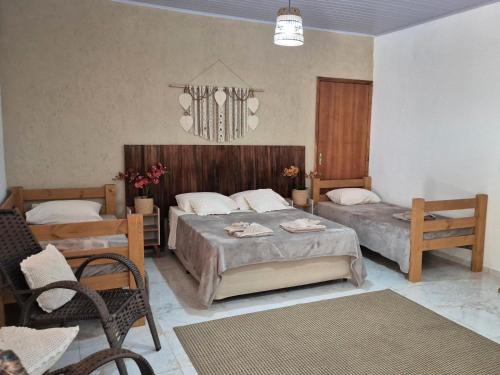 a bedroom with two beds and a chandelier at Pousada da Aline in Sete Barras