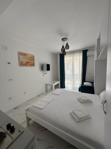 a white bedroom with a large bed and a window at Duo Apartments in Bar
