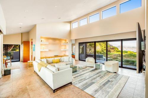 a living room with white furniture and large windows at Seaspray in Sea Ranch