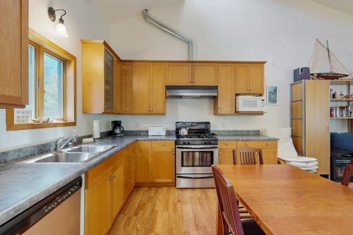 a kitchen with wooden cabinets and a wooden table at Loon's Landing in Sea Ranch