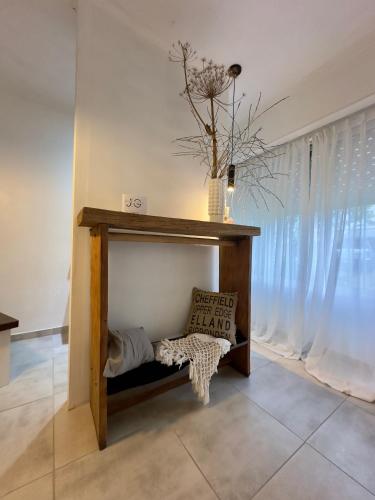 a room with a shelf with a pillow and a window at Entre Jazmines & Glicinas in Lobos