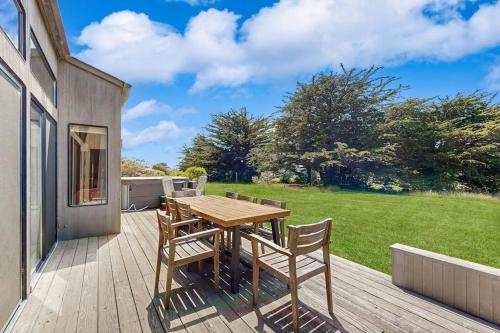 a wooden table and chairs on a deck at Hilma House in Sea Ranch