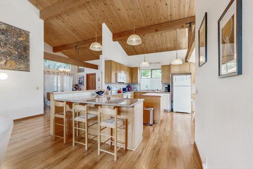 a kitchen with a large island with bar stools at Hilma House in Sea Ranch