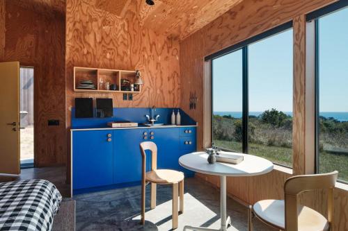 a room with a blue kitchen with a table and chairs at Wild Meadow in Sea Ranch