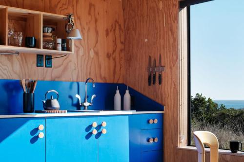 a blue kitchen with a blue counter and a window at Wild Meadow in Sea Ranch