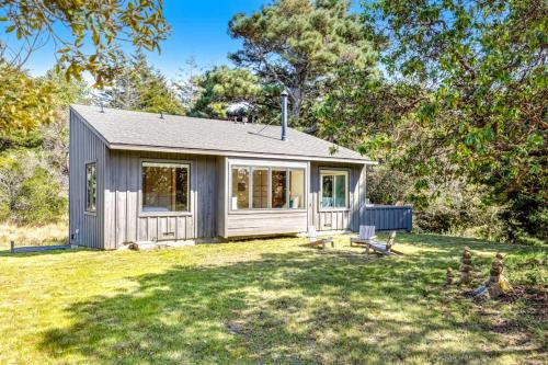 a small house in a field with a yard at Madrone Cottage in Sea Ranch