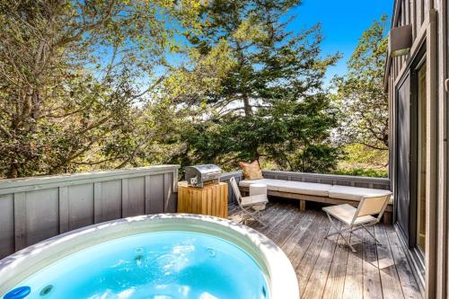 a jacuzzi tub on the patio of a house at Madrone Cottage in Sea Ranch