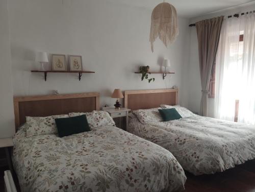 a bedroom with two beds and a window at El rinconcito in Fuenteheridos