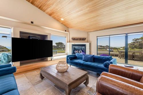 a living room with blue couches and a flat screen tv at Da Yaya House in Sea Ranch