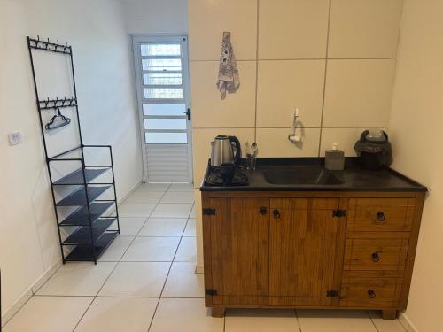 a kitchen with a sink and a counter top at SJ Suites in São José dos Pinhais