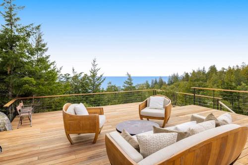 a deck with couches and chairs on a wooden deck at Sequoia Vista in Gualala