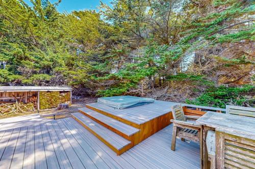 a wooden deck with a table and chairs and trees at Dune Drift in Sea Ranch