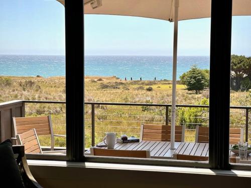a room with a view of the ocean from a balcony at Coastal Calm at Sea Ranch in Sea Ranch