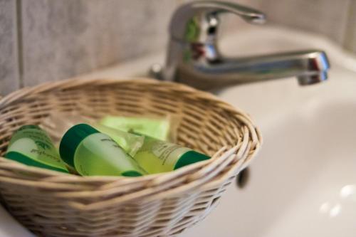 a basket of toothbrushes is sitting on a sink at Nestorion Hotel in Athens