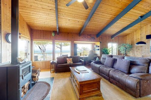 a living room with a leather couch and a fireplace at Eagle's Landing - Main House in Gualala