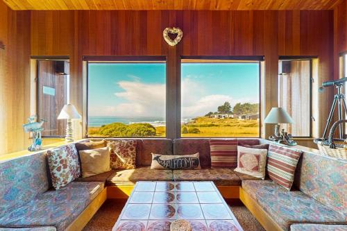 a living room with a couch and a large window at Touch the Tides in Sea Ranch