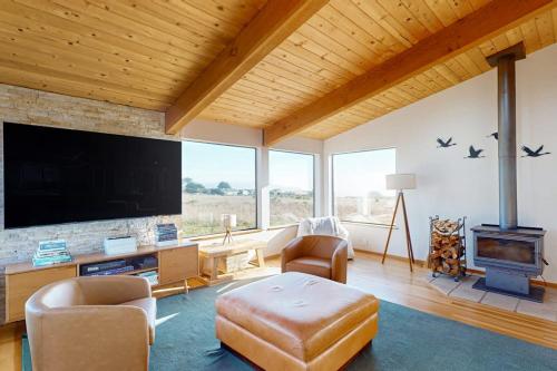 a living room with a large flat screen tv at Coffee by the Sea in Sea Ranch