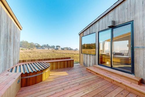 a wooden deck with a bench on a house at Coffee by the Sea in Sea Ranch