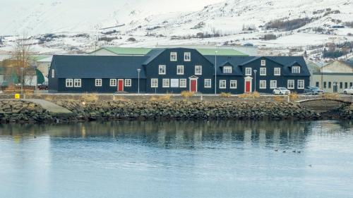 a large black building next to a body of water at Bryggjan Boutique Hotel in Akureyri