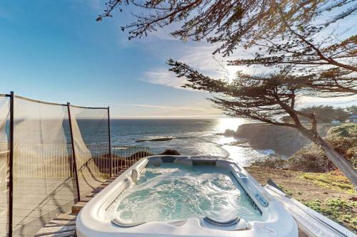 a bath tub sitting next to the ocean with a view at Oceanfront Dream Hideaway in Gualala