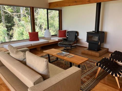 a living room with a couch and a wood stove at Madrone Meadow in Sea Ranch