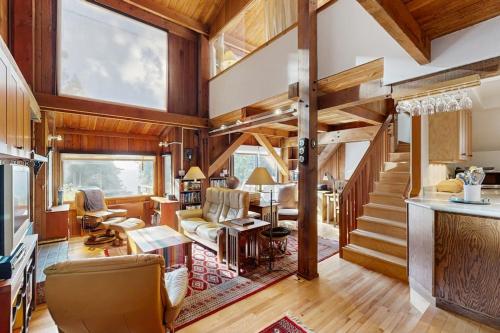 a living room with wooden ceilings and a staircase at Schooner in Sea Ranch