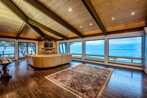 a large room with a large couch in a room with windows at Oceanfront Dream Hideaway and Retreat in Gualala